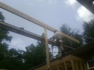 Carpenter setting a ridge beam over a new addition frame — Ice Dam Removal by Roofing Brothers in Fair Bluff