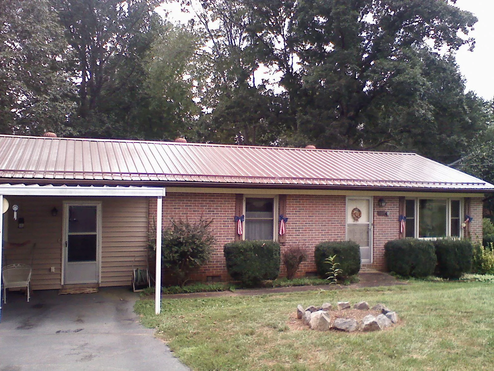 Bronze metal roof and carport on a brick ranch home — Roof Repair work by our crew in Fair Bluff